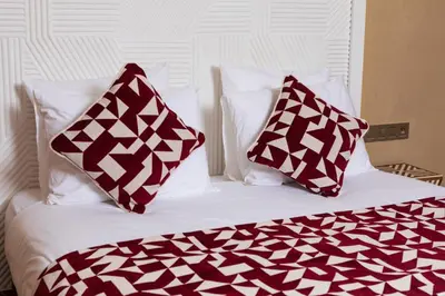 a bed with two red and white pillows on it at Riad Dar Shala in Marrakech