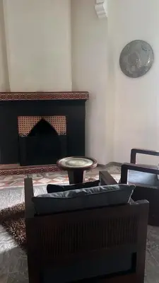 a living room with a table and a fireplace at Villa Oum Palace in Marrakech