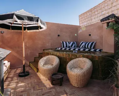 a patio with two chairs and an umbrella at Riad Ever - Entièrement privatisé in Marrakech