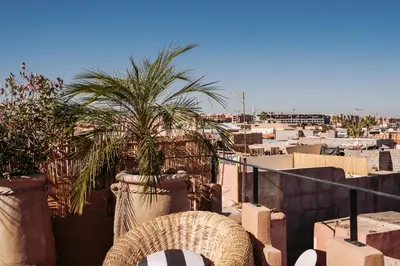 a view of a city from a balcony with a palm tree at Riad Ever - Entièrement privatisé in Marrakech