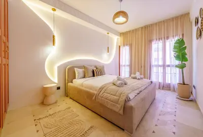 a bedroom with a large bed with lights above it at Appartement de luxe au Plaza, au coeur de Marrakech in Marrakech