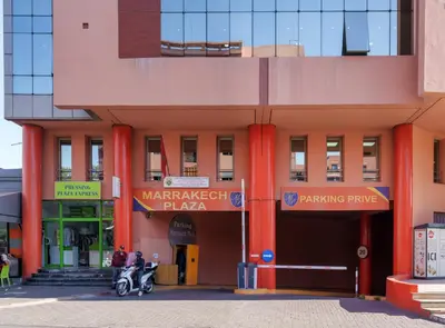 a building with two people on a scooter outside at Appartement de luxe au Plaza, au coeur de Marrakech in Marrakech