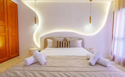 a bedroom with a white bed with white slippers on it at Appartement de luxe au Plaza, au coeur de Marrakech in Marrakech