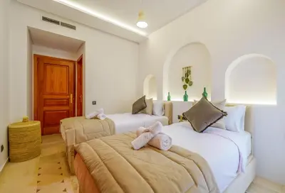 a bedroom with two beds with towels on them at Appartement de luxe au Plaza, au coeur de Marrakech in Marrakech