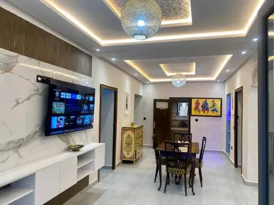 a dining room with a table and a tv on the wall at Villa d'Exception avec Piscine Privée in Marrakech