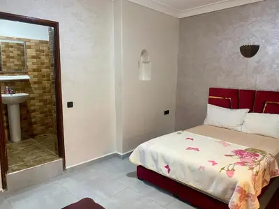 a bedroom with a bed and a bathroom with a sink at Villa d'Exception avec Piscine Privée in Marrakech