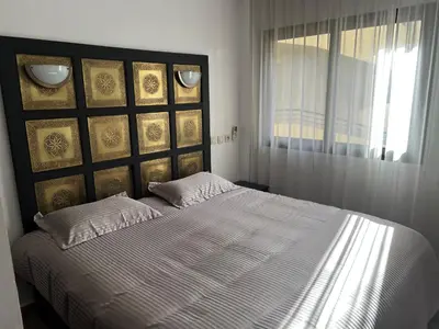 a bedroom with a large bed with a large window at Le petit cocon in Marrakech