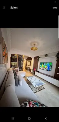 a living room with a couch and a flat screen tv at Le petit cocon in Marrakech