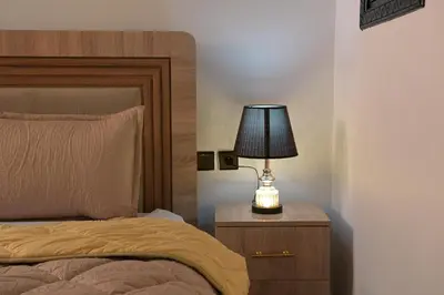 a bedroom with a bed and a lamp on a night stand at Riad Marrakech Golden Star 82 with 3 Rooms & Pool in Marrakech