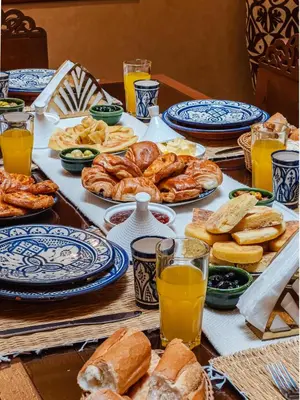 a table topped with plates of bread and pastries at Riad Marrakech Golden Star 82 with 3 Rooms & Pool in Marrakech