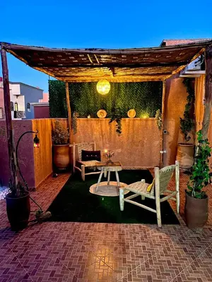 acovered patio with a table and a bench at Adomar Lighted Terrace Retreat, 2BR Comfort in Marrakech
