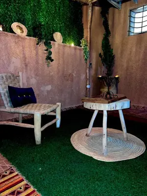 a patio with a bench and a table with a potted plant at Adomar Lighted Terrace Retreat, 2BR Comfort in Marrakech