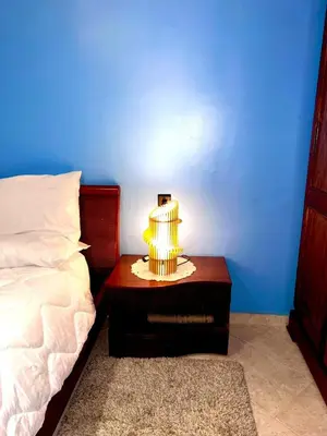 a table with a lamp on it next to a bed at Adomar Lighted Terrace Retreat, 2BR Comfort in Marrakech