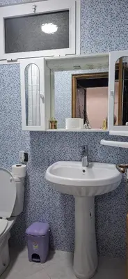 a bathroom with a sink and a toilet and a mirror at Adomar Lighted Terrace Retreat, 2BR Comfort in Marrakech
