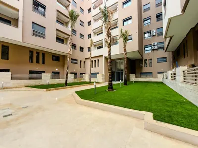a courtyard with palm trees in a building at Modern Studio Menara Garden in Marrakech