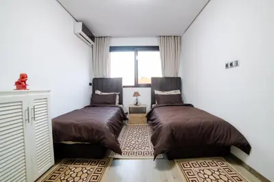 two beds in a room with a window at Appartemment top Marrakech in Marrakech