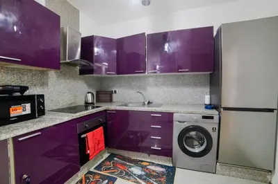a kitchen with purple cabinets and a washing machine at Appartemment top Marrakech in Marrakech