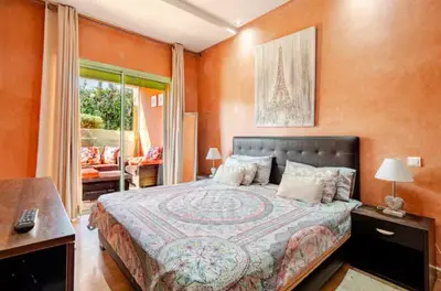 a bedroom with a large bed with orange walls at Appartement marrakech garden in Marrakech