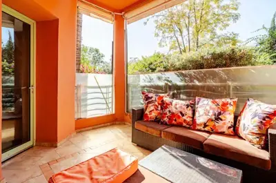 a screened in porch with a couch and a window at Appartement marrakech garden in Marrakech