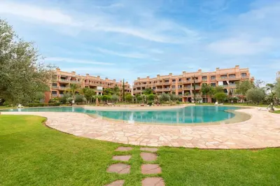 a large pool in the middle of a park with buildings at 3 BED Hidden Gem Self Check-in With Pool M6 BLVD in Marrakech