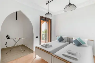 a white room with a bed and a table at 3 BED Hidden Gem Self Check-in With Pool M6 BLVD in Marrakech
