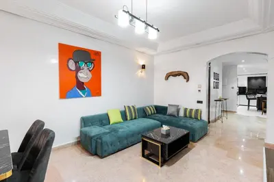 a living room with a green couch and a painting at 3 BED Hidden Gem Self Check-in With Pool M6 BLVD in Marrakech