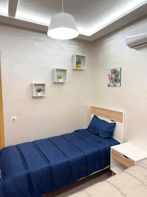 a bedroom with a blue bed and a white wall at Gueliz Bright & Modern 2BR 2 Balcons in Marrakech