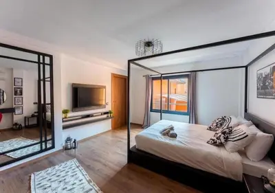 a bedroom with a large bed with a glass wall at Écrin Cosy au Cœur de Guéliz Emplacement Central in Marrakech