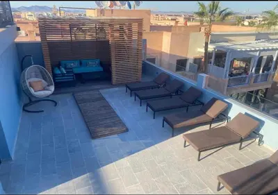a patio with a couch and chairs on a roof at Écrin Cosy au Cœur de Guéliz Emplacement Central in Marrakech