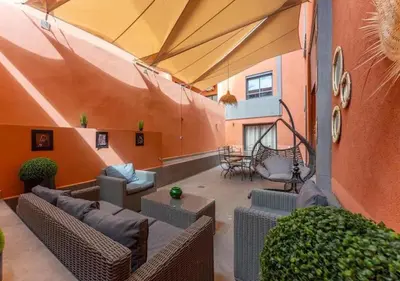 an outdoor patio with couches and chairs in a building at Écrin Cosy au Cœur de Guéliz Emplacement Central in Marrakech