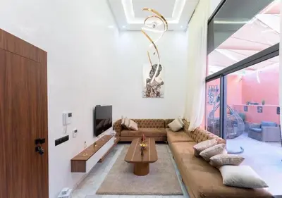 a living room with a large couch and a table at Écrin Cosy au Cœur de Guéliz Emplacement Central in Marrakech
