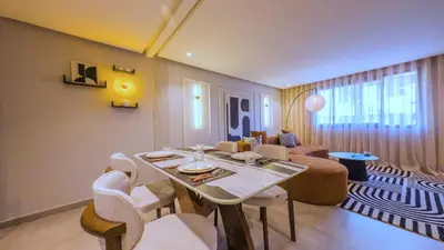 a living room with a table and chairs and a couch at MOZAIC26 I Terrasse & Piscine couverte I Hivernage in Marrakech