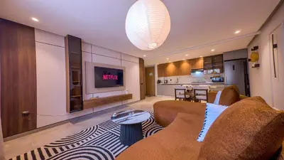 a living room with a couch and a tv at MOZAIC26 I Terrasse & Piscine couverte I Hivernage in Marrakech