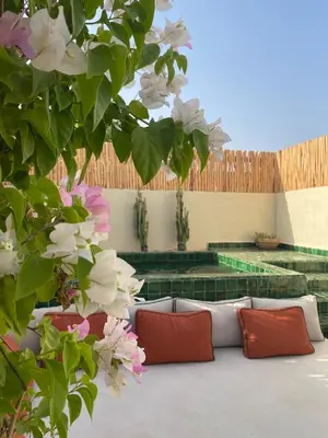 a living room with a couch and some flowers at Riad Costa 2 privates pools rooftop breakfast in Marrakech