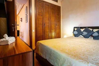 a bedroom with a bed with blue pillows on it at Appartement de charme avec piscine a Marrakech in Marrakech