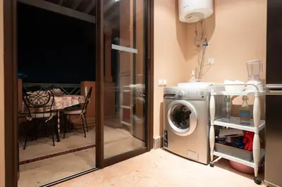 a laundry room with a washing machine and a table at Appartement de charme avec piscine a Marrakech in Marrakech