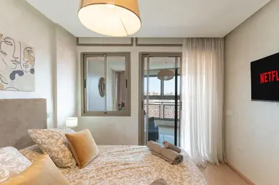 a bedroom with a bed and a view of a balcony at Bright & Chic Stay in Marrakech Gueliz in Marrakech