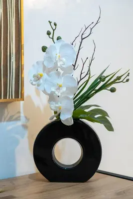 a black vase with white flowers in it at Bright & Chic Stay in Marrakech Gueliz in Marrakech