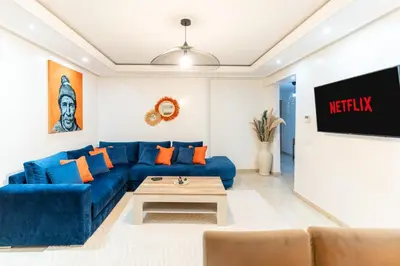 a living room with a blue couch and a tv at Bright & Chic Stay in Marrakech Gueliz in Marrakech