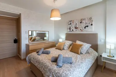 a bedroom with a bed with pillows and a mirror at Bright & Chic Stay in Marrakech Gueliz in Marrakech
