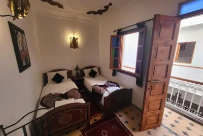 a room with two beds and a window at Riad Granada in Marrakech