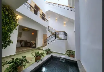 a swimming pool in the middle of a house with stairs at Riad Granada in Marrakech