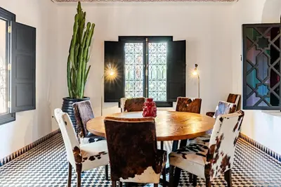 a dining room with a wooden table and chairs at Magnifique Villa EME, Golf Amelkis Marrakech - Piscine Chauffée in Marrakech
