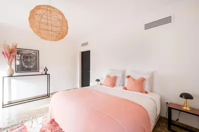 a bedroom with a large bed with pink pillows at Magnifique Villa EME, Golf Amelkis Marrakech - Piscine Chauffée in Marrakech