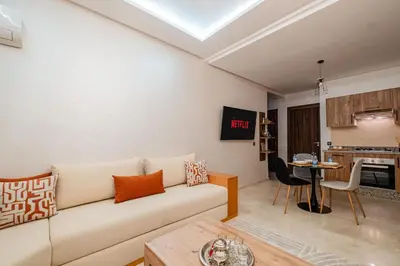 a living room with a couch and a table at 1BR Cosy 2 min M Avenue Parking, Piscine & Fibre in Marrakech
