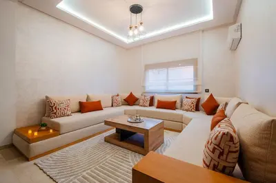 a living room with a couch and a table at 1BR Cosy 2 min M Avenue Parking, Piscine & Fibre in Marrakech