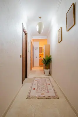 a hallway with a rug on the floor at 1BR Cosy 2 min M Avenue Parking, Piscine & Fibre in Marrakech