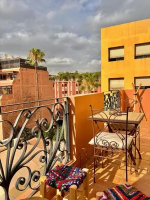 a balcony with a table and chairs on a building at Cozy appartment - private terrace - Gueliz in Marrakech