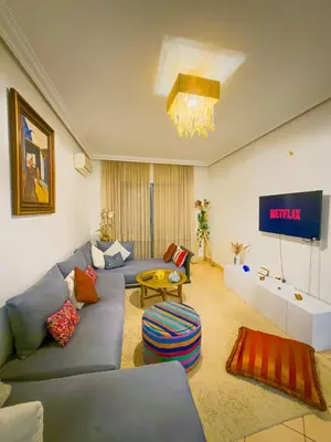 a living room with a blue couch and a tv at Cozy appartment - private terrace - Gueliz in Marrakech