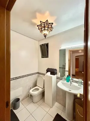 a bathroom with a toilet and a sink and a chandelier at Cozy appartment - private terrace - Gueliz in Marrakech